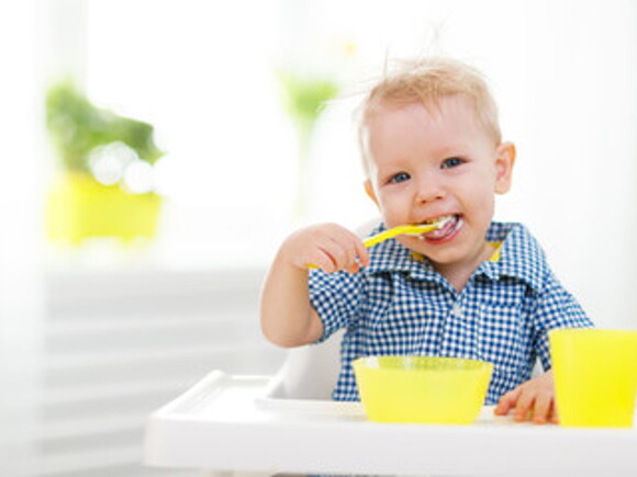 Niño rubio comiendo alegre un menú infantil
