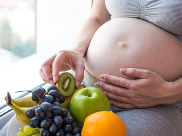 Mujer en embarazo con frutas y alimentos para el embarazo