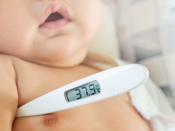 Bebé con termómetro debajo del brazo