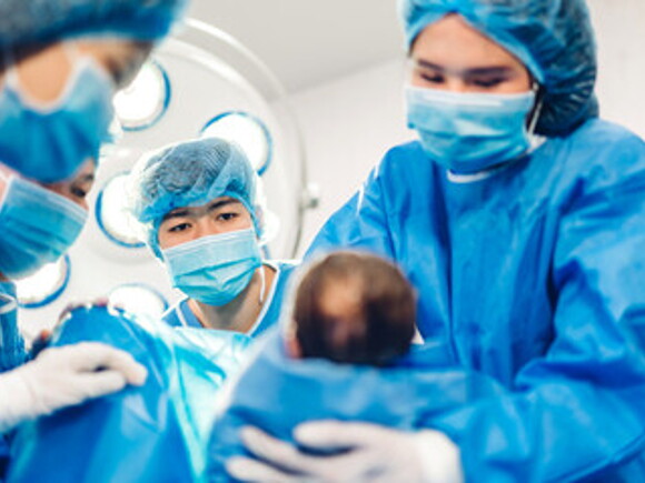 Doctores cargando bebé prematuro luego del parto