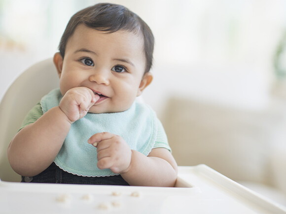 Bebé de 9 meses sentado sonriendo