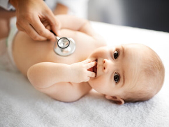 Pediatra con estetoscopio escuchando los latidos del corazón o la respiración de bebé