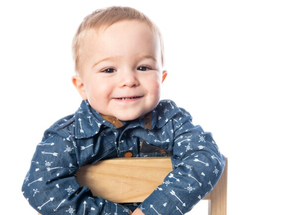 Bebé sonriendo mientras está sentado sobre una silla