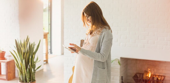 Mujer embarazada mirando un dispositivo