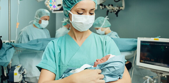 Enfermera alzando al bebé luego del parto inducido