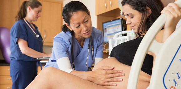 Enfermera ayudando a la madre en el proceso del parto inducido